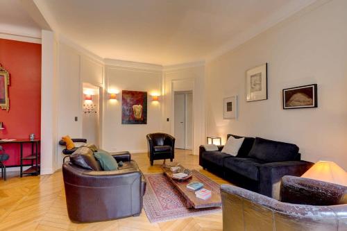 sala de estar con sofá y mesa en The Seine & Pont de l'Alma - CityApartmentStay en París