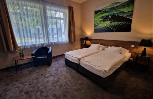 1 dormitorio con 1 cama y una gran pintura en la pared en Garda Hotel, en Szombathely