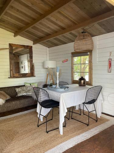 a room with a table and chairs and a bed at Luxury Experience in Off The Grid Lodge at an Amazing Lake Vinkeveense Plassen in Vinkeveen