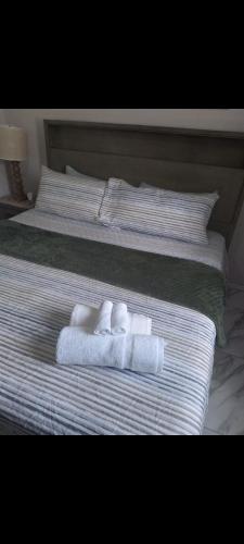a bed with two towels and two pillows on it at Shauna apartment in Charlton