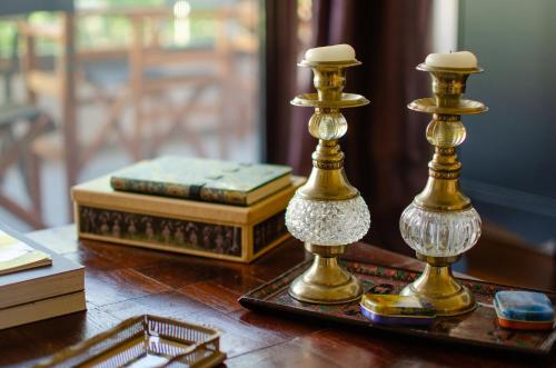 dois castiçais de ouro sentados numa mesa com livros em Luxury City One-bedroom Apartment em Heraclião