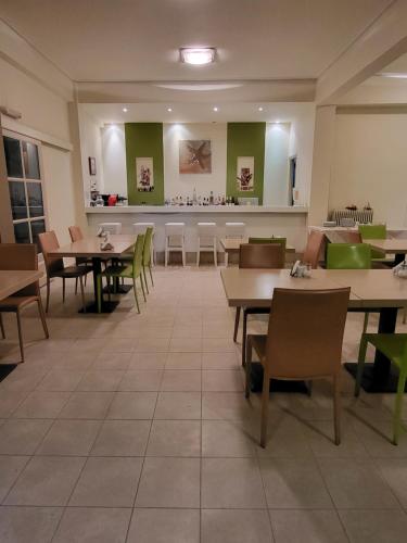 un restaurante con mesas, sillas y una barra en ASTIR COSY LIVING HOTEL, en Áyios Konstandínos