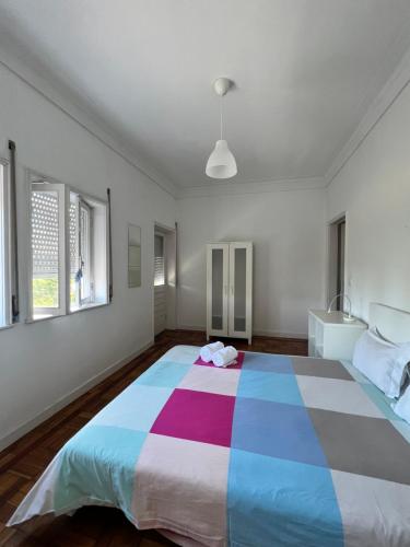a bedroom with a large bed with a colorful blanket at Relógio Guest House in Porto