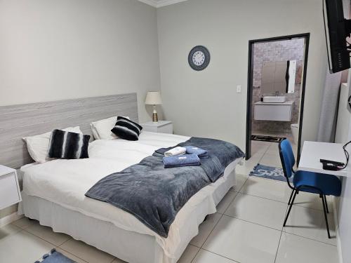 1 dormitorio con 1 cama grande y espejo en Li-Bru Self Catering Accommodation en Windhoek