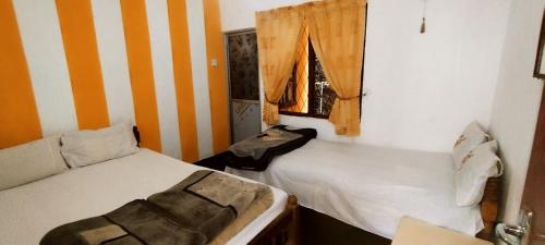 a room with two beds and a window at Rizi Bungalow In Nuwara Eliya in Nuwara Eliya