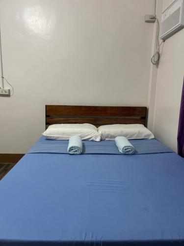 łóżko w pokoju z niebieskim światłem w obiekcie Maria kulafu studio 2 w Masbate