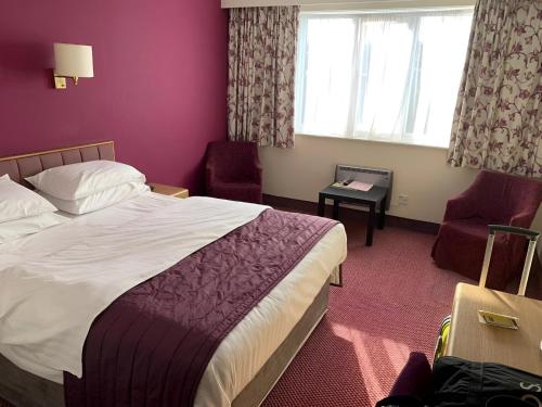 a hotel room with a bed and a window at Supreme Inns Boston in Swineshead