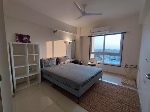 a bedroom with a bed and a large window at Beta Room in Ahmedabad