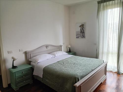 um quarto com uma cama com uma mesa de cabeceira verde e uma janela em Casa Emilia - Appartamento per vacanze - Foligno em Foligno