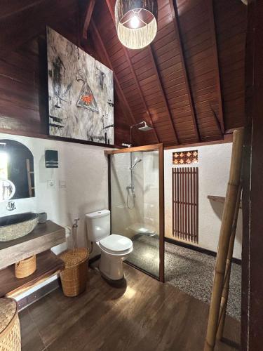 Un baño con inodoro, ducha y lavabo. en Uma Sepi Villa, en Sukawati