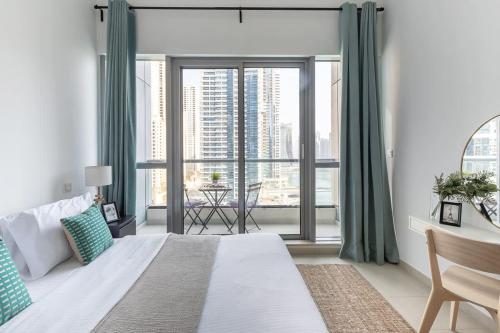 a bedroom with a bed and a large window at Frank Porter - BayCentral in Dubai