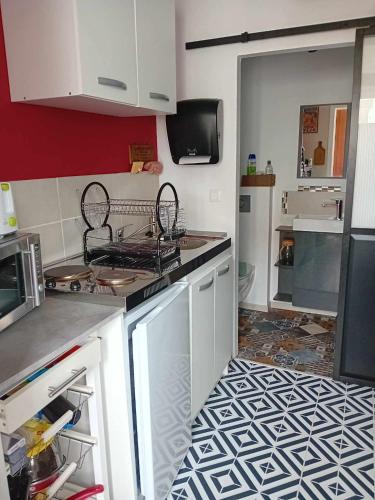 une cuisine avec une cuisinière et un comptoir dans l'établissement Petite maison indépendante, au Havre