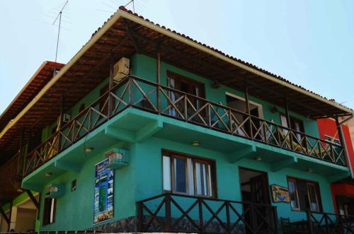 a green building with a balcony on the side of it at Pousada Tranquila in Morro de São Paulo