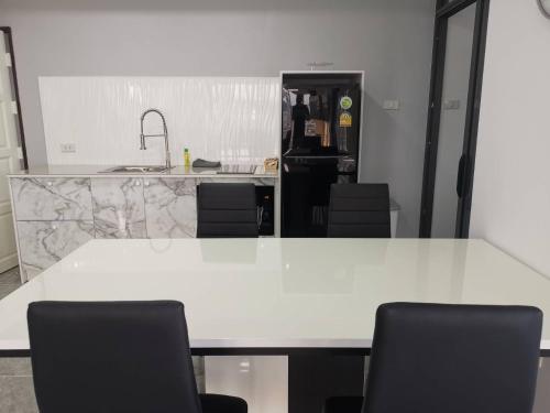 a white table with black chairs in a kitchen at View Talay6 by Blue Ocean Suite in Pattaya Central