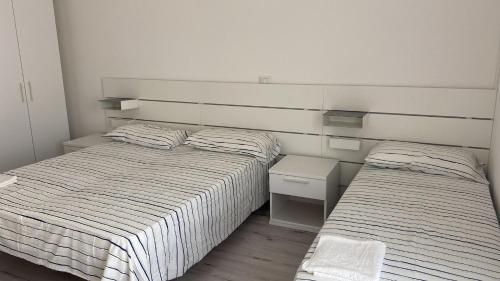 - 2 lits installés l'un à côté de l'autre dans une chambre dans l'établissement SoleMare, à Bellaria-Igea Marina