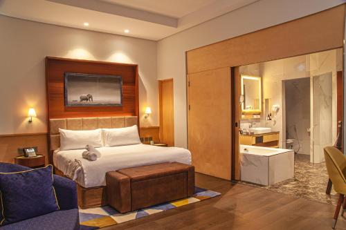 a hotel room with a bed and a bathroom at The Quorum in Lusaka