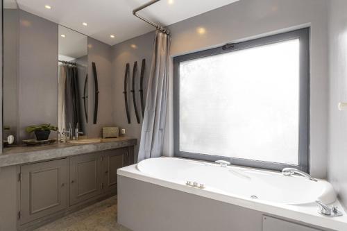 bagno con vasca e ampia finestra di Carmim Villa by Cadenzalux a Malveira da Serra