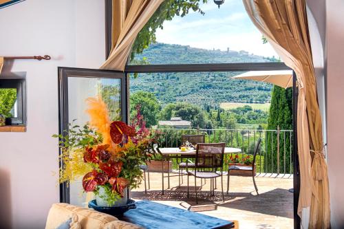 a living room with a table and a balcony with a view at Il Falconiere Relais & Spa in Cortona