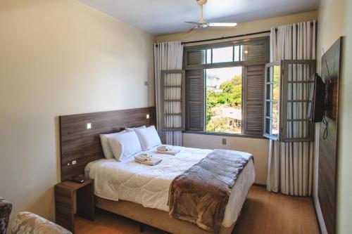 a bedroom with a large bed and a window at Pousada Convento São Lourenço in Porto Alegre