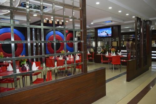 un restaurant avec des chaises rouges et une salle à manger dans l'établissement Five Mounts Hotel And Restaurant, à Multan