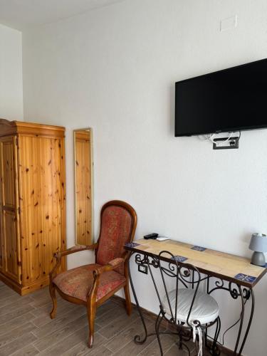 a room with a desk and a chair and a television at Iloghe di Marras in Dorgali