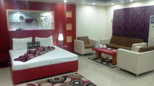 - une chambre avec un lit, deux chaises et un canapé dans l'établissement Five Mounts Hotel And Restaurant, à Multan