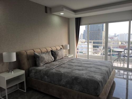 a bedroom with a large bed and a large window at View Talay6 by Blue Ocean Suite in Pattaya Central