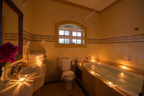 a bathroom with a tub and a toilet and a sink at Confraria Colonial Hotel Boutique in Mairinque
