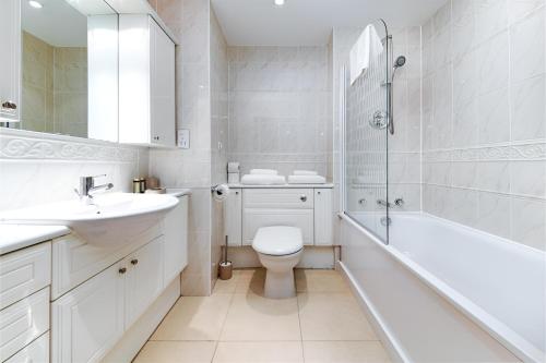 ロンドンにあるClerkenwell Serviced Apartmentsの白いバスルーム(洗面台、トイレ、バスタブ付)