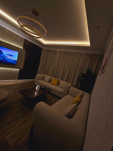 sala de estar con 2 sofás y TV en شقة مودرن غرفة وصالة في الملقا, en Riad