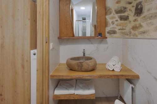 y baño con lavabo, espejo y toallas. en Villa Charaso Maritina private pool by Estia, en Kharasón
