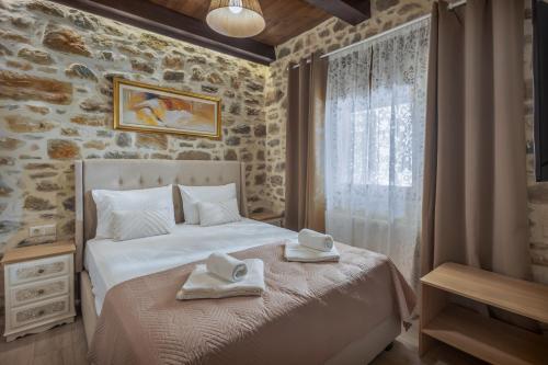 a bedroom with a bed with towels on it at Villa Charaso Maritina private pool by Estia in Kharasón