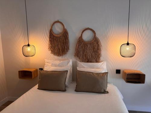 アルカラ・デ・エナレスにあるLAAN Los pinosのベッドルーム1室(3つの吊り下げ式ライト付きベッド1台付)