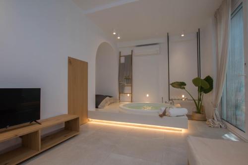 奧林匹亞達的住宿－Aristotelia Gi - Premium Luxury Villas with Private Pools，一间带浴缸的浴室和一台电视。