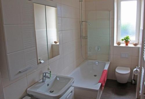 a bathroom with a tub and a sink and a toilet at Am Apfelbaum 4 Pers in Röbel