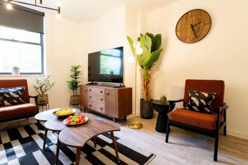 - un salon avec une télévision, une table et des chaises dans l'établissement Waterside 2Bed Apartment Taunton, à Taunton