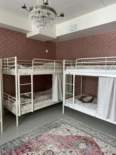 two bunk beds in a room with a chandelier at Hostel Cafe Huvila in Oulu