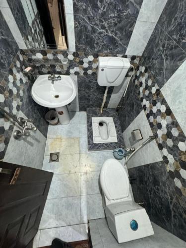 ein Bad mit einem WC und einem Waschbecken in der Unterkunft Millat Hotel in Islamabad