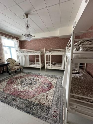 a bedroom with two bunk beds and a rug at Hostel Cafe Huvila in Oulu