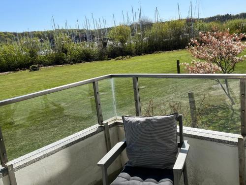 une chaise sur un balcon avec vue sur un champ dans l'établissement Ferienwohnung Sailing, à Schausende
