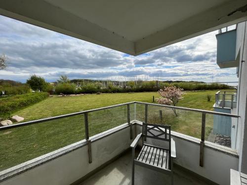 d'un balcon avec un banc et une pelouse. dans l'établissement Ferienwohnung Sailing, à Schausende