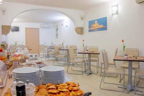 a restaurant with tables and chairs and plates of food at Porta delle Botteghelle in Trapani