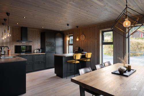 a kitchen and dining room with a wooden ceiling at Nesfjellet in Nes i Ådal