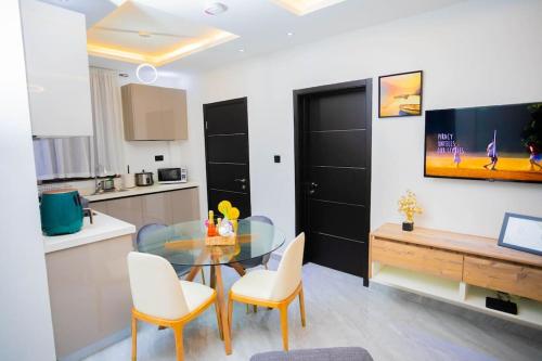 a kitchen and dining room with a glass table and chairs at The Pearl - Legacy - 4th floor in Kumasi