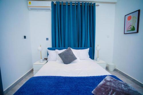 a bedroom with a blue curtain and a bed at The Pearl - Legacy - 4th floor in Kumasi
