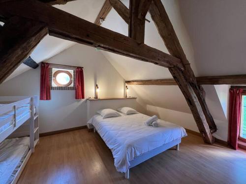 um quarto com uma cama num sótão em Les Petites Bergeonnières em Courmemin