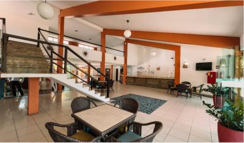 a lobby with a staircase and a table and chairs at Hotel Beach Hills in Porto Seguro