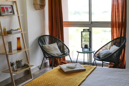 une chambre avec deux chaises, un lit et une fenêtre dans l'établissement Studio avec parking vue sur la Cité de Carcassonne, à Carcassonne