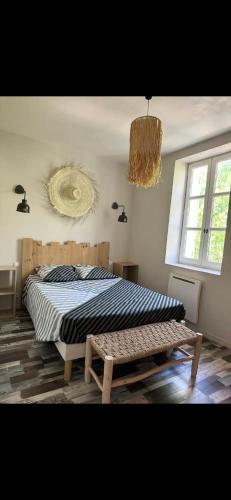 Schlafzimmer mit einem Bett, einem Fenster und einem Kronleuchter in der Unterkunft L’oustau St Bernard in Saint-Rémy-de-Provence