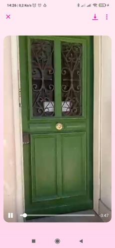 une porte verte avec deux fenêtres au-dessus dans l'établissement appartement centre de Cannes, à Cannes